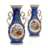 Paire de vases balustres en porcelaine bleue et or. A décor de fleurs en médaillon- les anses en