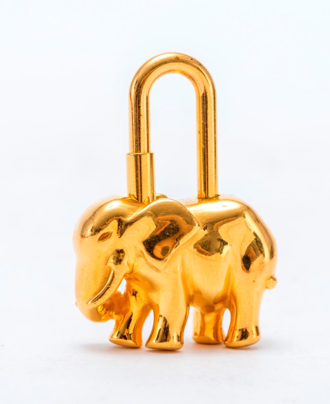 Hermès- cadenas  éléphant en métal plaqué or- housse