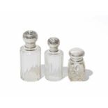 Suite de 3 flacons en verre taillé et bouchons en argent. 2 de forme cylindrique à pans coupés- le