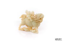 A CHINESE CARVING OF A BOY RIDING A MYTHICAL BEAST