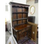 A small oak dresser, the raised back fitted two shelves, the base fitted frieze drawer, cupboards