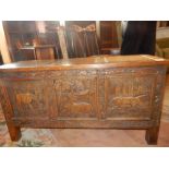 A small oak coffer with hinged lid, carved panelled front in three sections depicting animals - 35