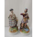 A pair of Victorian porcelain figures of a Scotsman and his lady - 11 3/4in. high