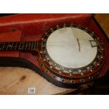 A four string banjo with mother of pearl inlay to the fret board, in fitted case