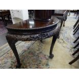 A Chinese style mahogany half round table with carved edge, flower and leaf frieze, on cabriole legs