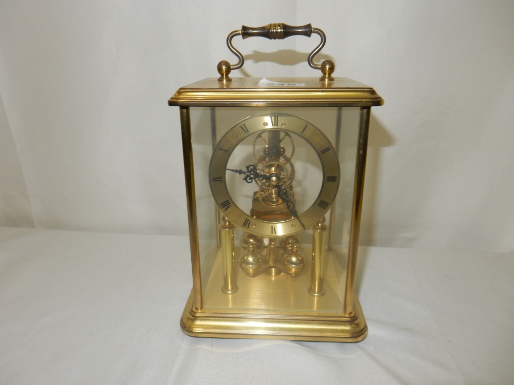 A 400 day clock under a glass dome and one other carriage style clock in a brass and glass case