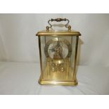 A 400 day clock under a glass dome and one other carriage style clock in a brass and glass case