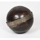A leather cricket ball mounted with a silver presentation band