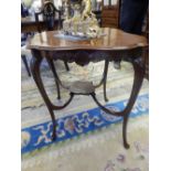 An Edwardian mahogany occasional table with shaped oval top, anthemion and leaf scroll border, on