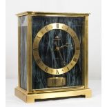 A Jaeger Le Coultre Atmos clock with marbled effect dial, in a brass and glass case - 8 3/4in. high