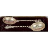 A pair of Eastern silver serving spoons with engraved decoration to the bowls, twin snake form