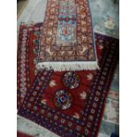 Two similar Eastern rugs, red field with repeating medallion decoration and one other rug, blue, red