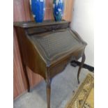 A French mahogany bonheur de jour with 3/4 pierced brass gallery, hinged fall front with basket