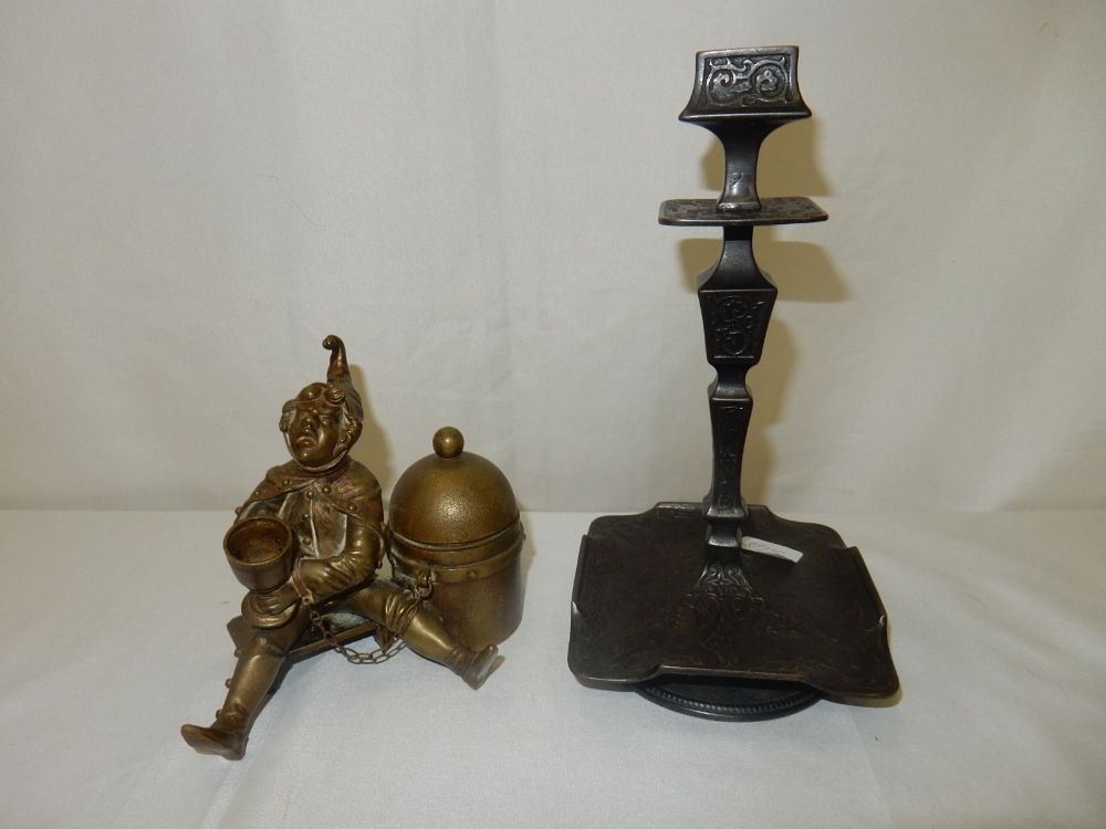 A bronze coloured inkwell in the form of a jester with cup, seated on a stool and a pair of bronze