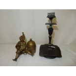 A bronze coloured inkwell in the form of a jester with cup, seated on a stool and a pair of bronze