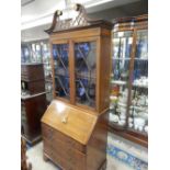 An Edwardian mahogany and satinwood crossbanded bureau bookcase, the upper part with scrolling and