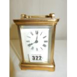 A carriage clock with white enamel dial, in a brass and bevelled glass case - 4in. high