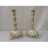 A pair of candlesticks, white with gilt decoration, on leaf form feet, a blue and white meat