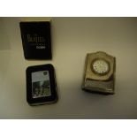 A Carrs modern silver fronted clock to commemorate Concorde and a Beatles Zippo lighter, boxed