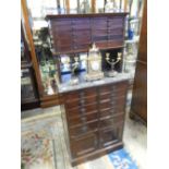 A dentist's cabinet, the raised back fitted ten small drawers above mirrored back and grey marble