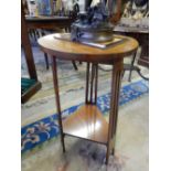 An Edwardian walnut Arts and Crafts style table with circular top, on three pierced legs with