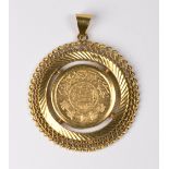 A Saudi Arabian gold guinea coin mounted in a gold coloured metal frame as a pendant