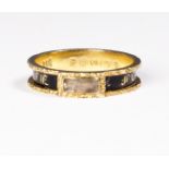 A 19th Century mourning ring with black enamel decoration and hair to the front, on an 18ct. gold