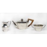 A silver three piece spinsters tea service of panelled form - London 1897, makers mark for William