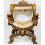 A walnut framed throne style chair with gilded cupid and shell decoration, scroll arms, on 'X'