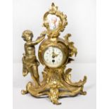 A 19th Century mantel clock with white enamel dial, in a gilded spelter case, the top inset portrait