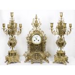 A reproduction mantel clock with white enamel dial, in a pierced brass case and a pair of matching