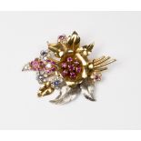 An 18ct. two colour gold brooch in the form of a spray of flowers set rubies, sapphires and