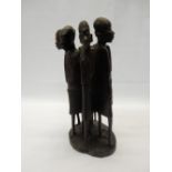 An African carved wood group of six figures, on oval base - 12in. high