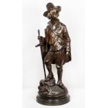 A bronze study of a peasant boy holding a staff, a bag over his sholder, on circular base signed