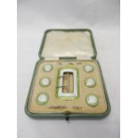 A silver buckle and dress button set decorated in lime green and white enamel, in fitted box