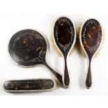 A pair of silver and tortoiseshell backed hairbrushes, matching clothes brush and hand mirror -