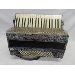 A Carloti Casino IV German accordion in a grey marbled effect case