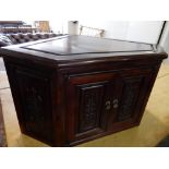 A Chinese style hardwood corner cupboard with raised decoration to the panelled door - 28in. wide