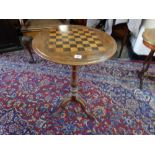 A Victorian walnut games table with circular top inset chess board, on turned column and three