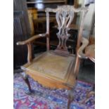 A Chippendale design mahogany commode chair with hinged cane seat, on cabriole legs terminating in