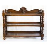 A Victorian mahogany three tier buffet with leaf carved pediment, turned finials, baluster turned