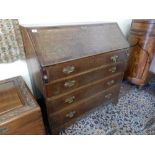 A Georgian oak bureau with hinged fall front enclosing fitted interior above four wide drawers, on