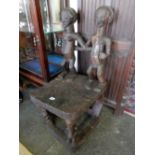 A tribal carved wood chair, the back with two figures, raised on figural form legs - 34in. high