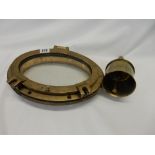 An oval brass port hole and a First World War brass handled shell case