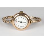 A lady's wristwatch with white enamel dial, in a 9ct. gold case, on a 9ct. gold expanding bracelet