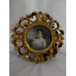A portrait of an Edwardian lady in pink and lace dress, in a circular Florentine frame and