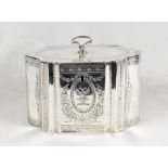 A George III silver tea caddy of serpentine form, engraved decoration of flowers and leaves - London