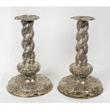 A pair of Continental silver candlesticks with all over repousse floral decoration, one marked ABI