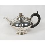 A George IV silver spinsters teapot of circular form, the hinged lid with flower form finial, on