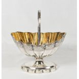 A George III silver sugar basket of oval fluted form, reeded swing handle gilt washed interior,